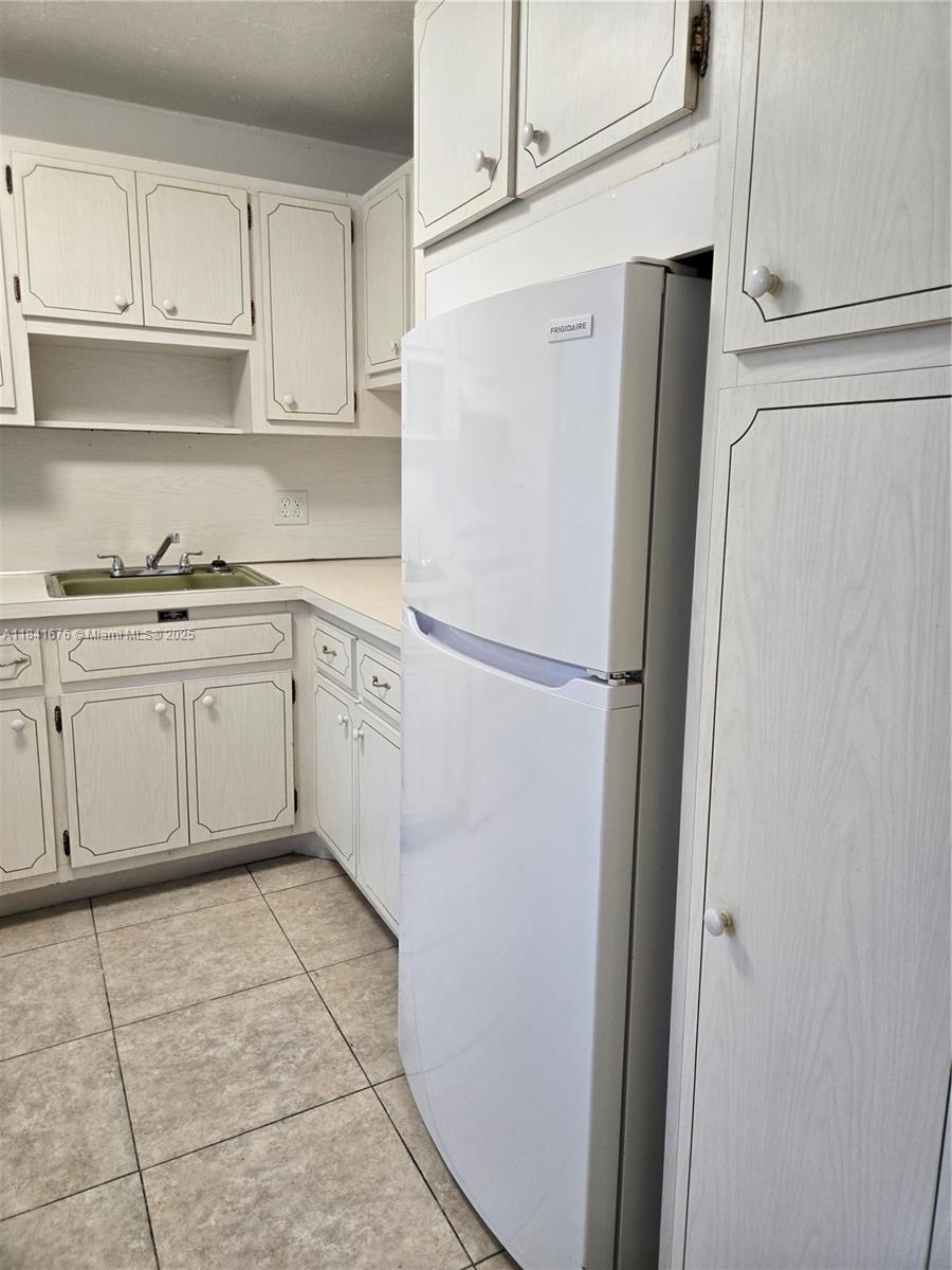 950 Hillcrest Drive, Unit 106 Hollywood, FL 33021 - Photo 10 of 30 a kitchen with stainless steel appliances white cabinets and a refrigerator