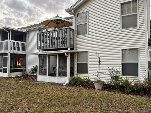 a view of a white house with large windows and potted plants