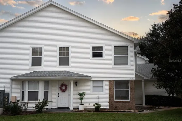 a front view of a house with a garden and trees
