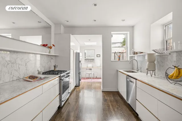 a kitchen with stainless steel appliances a stove a sink and a refrigerator