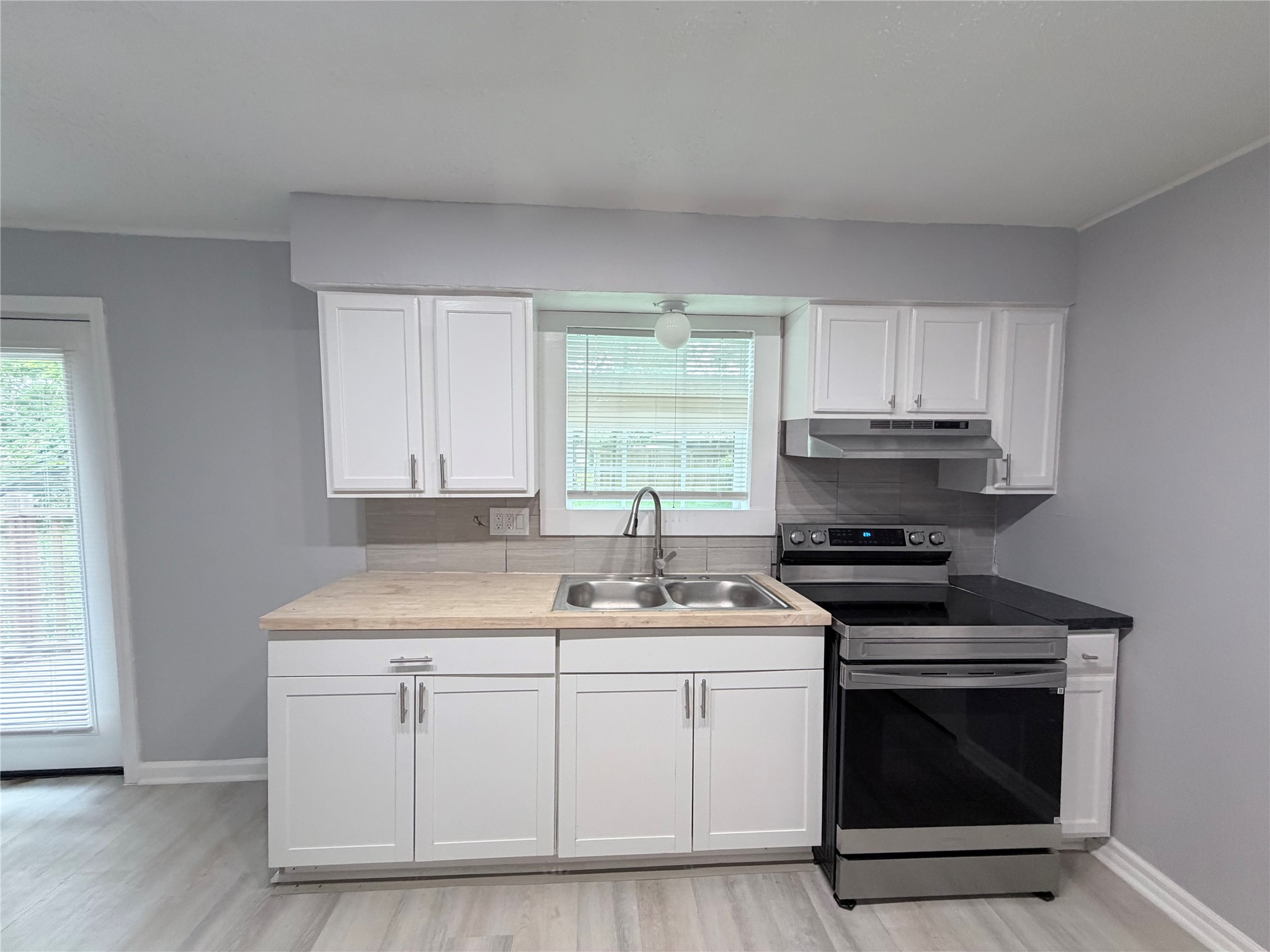 1903 Little Street La Marque, TX 77568 - Photo 12 of 18 a kitchen with white cabinets stainless steel appliances and sink