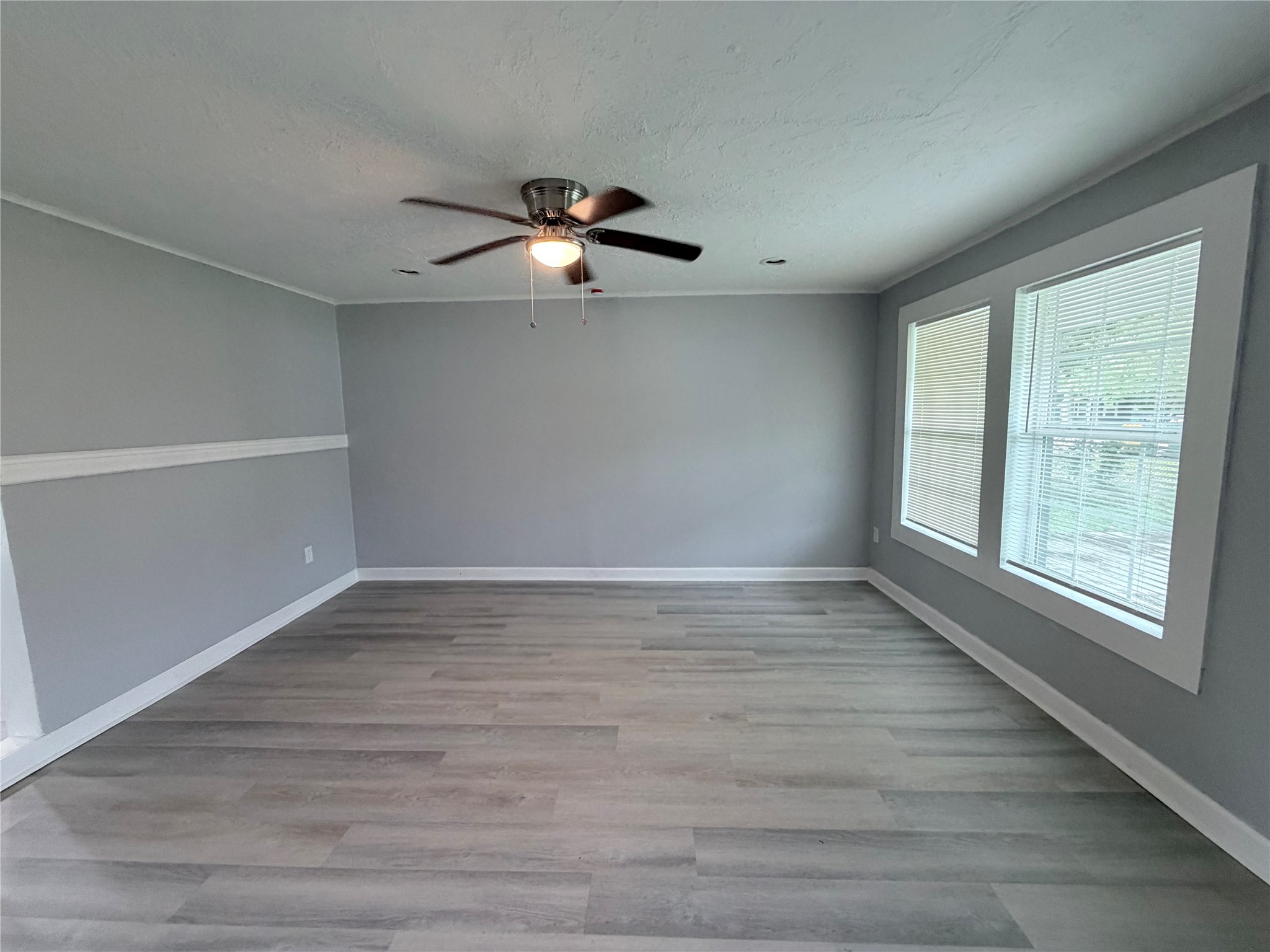 1903 Little Street La Marque, TX 77568 - Photo 4 of 18 an empty room with wooden floor fan and windows