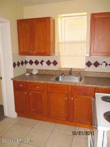 3902 Brick Road Jacksonville, FL 32209 - Photo 4 of 6 a kitchen with granite countertop cabinets and window