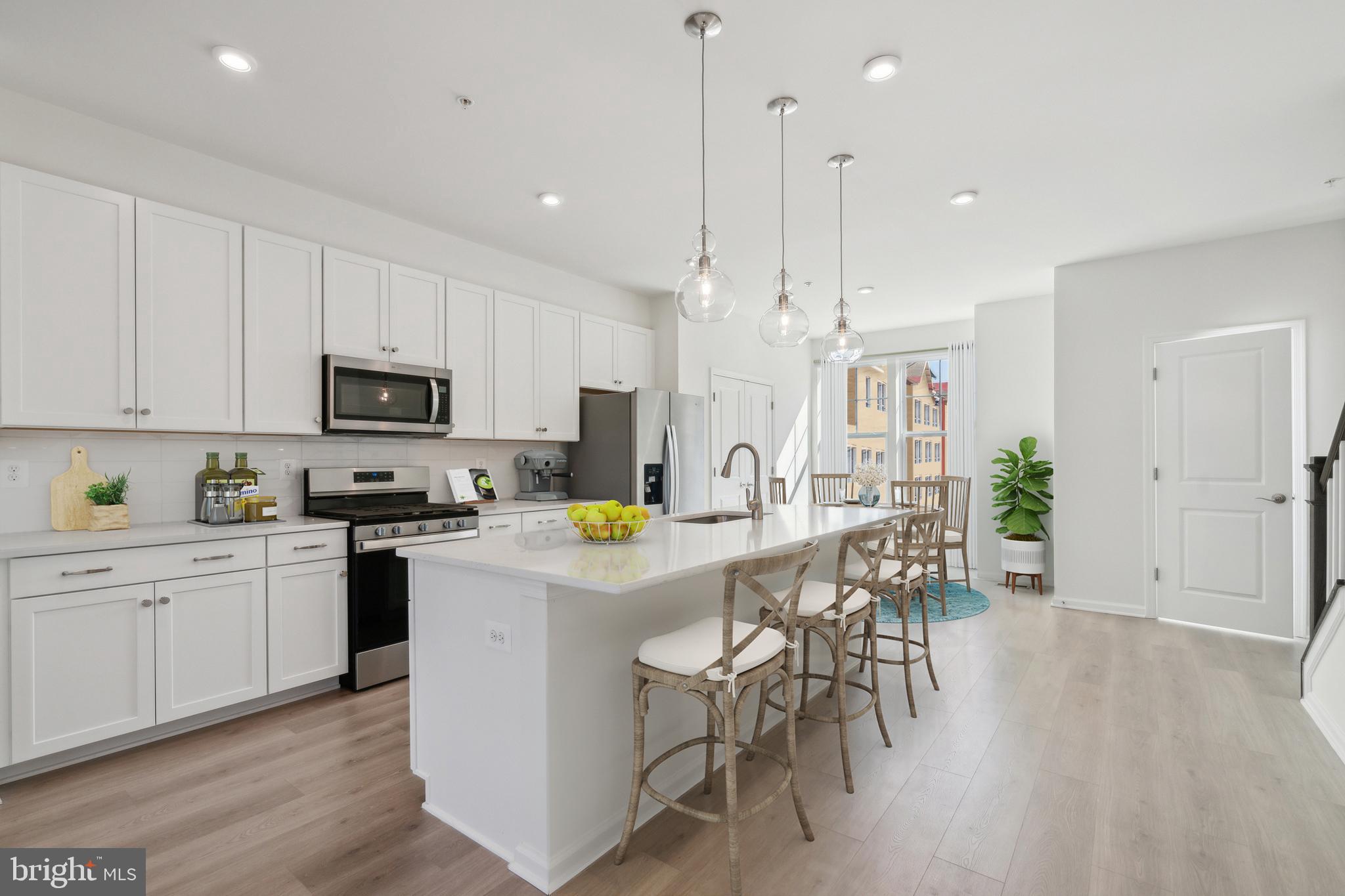 20 Riverside Drive Cambridge, MD 21613 - Photo 4 of 17 a kitchen with stainless steel appliances granite countertop a stove top oven a refrigerator a sink and white cabinets with wooden floor