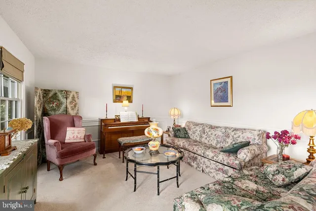 a living room with furniture fireplace and a large window