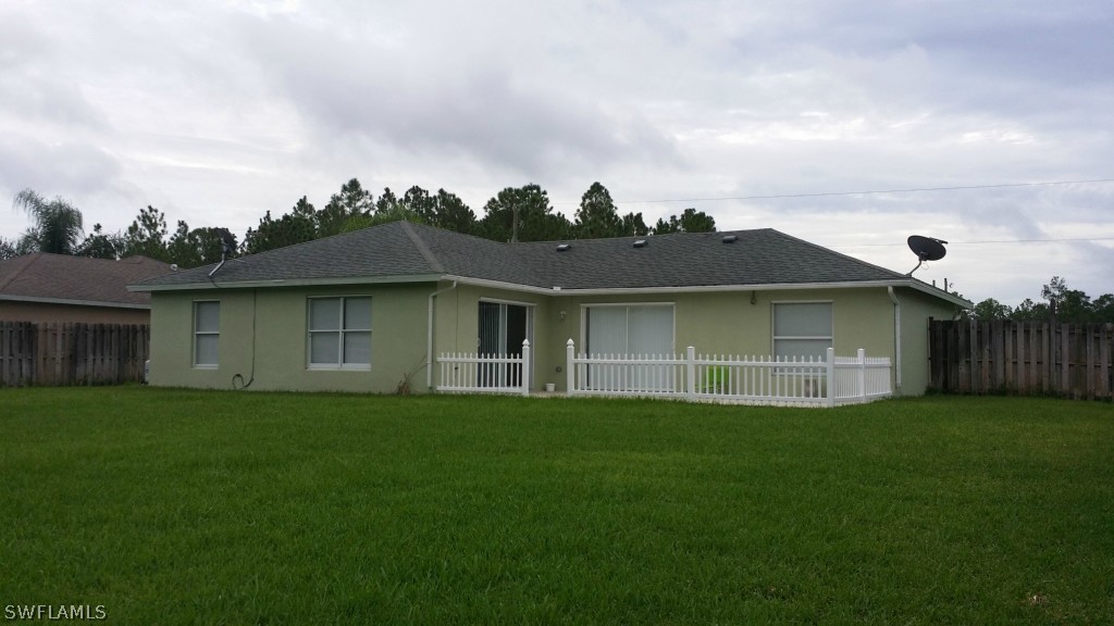 134 Ridgemont Drive Lehigh Acres, FL 33972 - Photo 13 of 14 a backyard of a house with lots of green space and plants