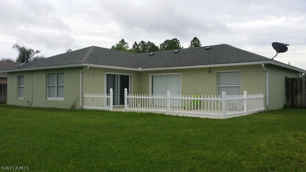 134 Ridgemont Drive Lehigh Acres, FL 33972 - Photo 14 of 14 a front view of a house with a garden