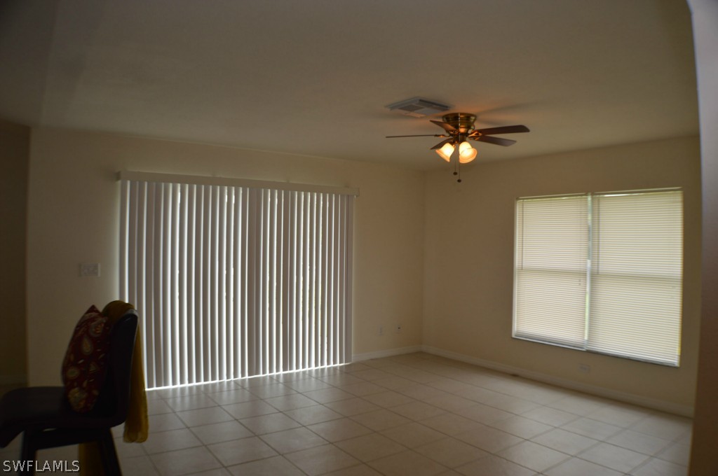 134 Ridgemont Drive Lehigh Acres, FL 33972 - Photo 8 of 14 an empty room with windows and fan