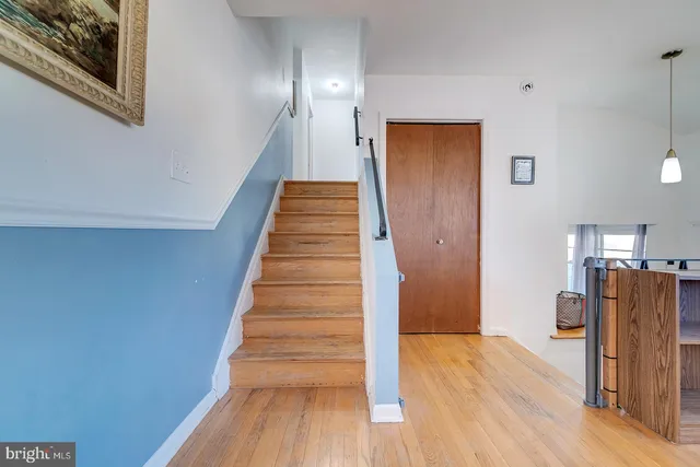 a view of a hallway with wooden floor and staircase