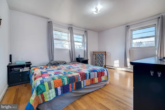 a bedroom with a bed and a lamp on dresser