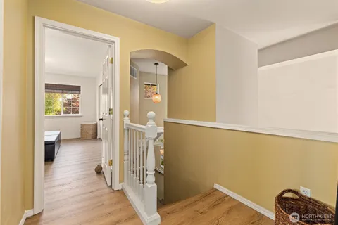 a view of a livingroom with wooden floor and a bathroom