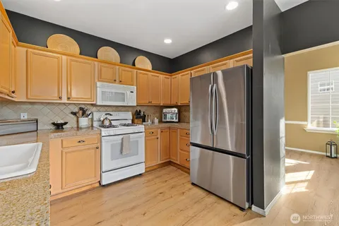 a kitchen with stainless steel appliances granite countertop a refrigerator sink and cabinets