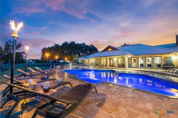 a view of a house with swimming pool and sitting area