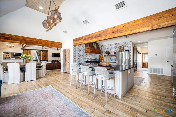 a living room with stainless steel appliances kitchen island granite countertop furniture and a view of kitchen