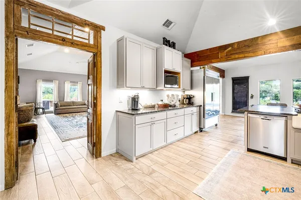 a large white kitchen with granite countertop a sink and cabinets