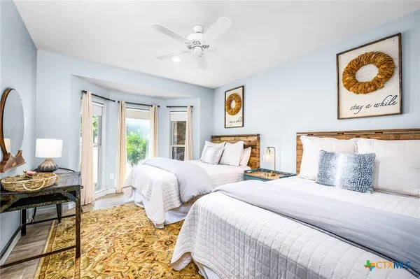 a bedroom with two beds and painting on the wall