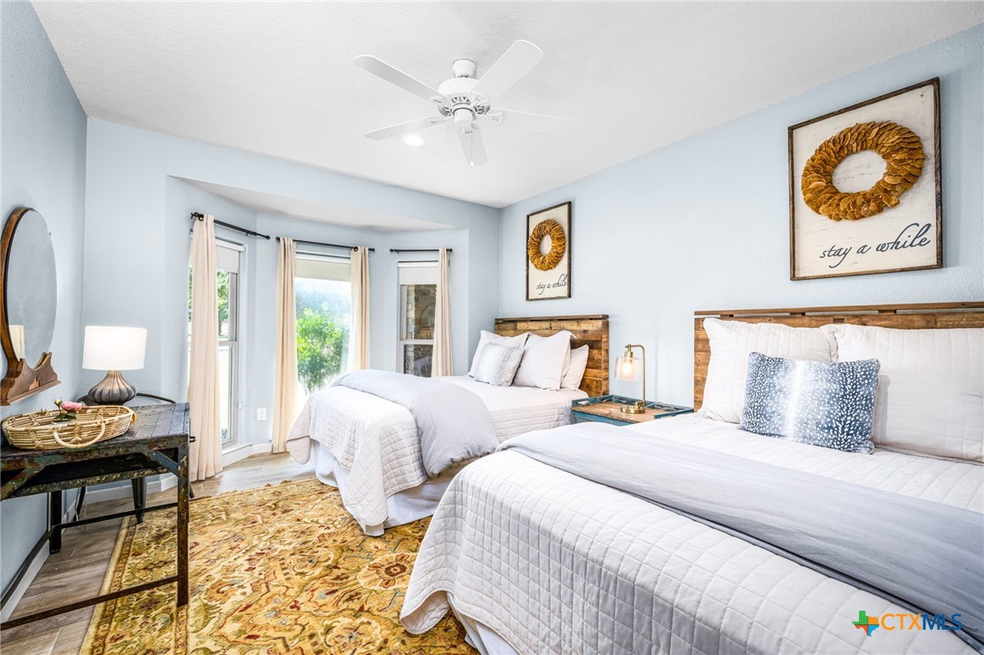 871 Chimney Valley Road Blanco, TX 78606 - Photo 29 of 45 a bedroom with two beds and painting on the wall