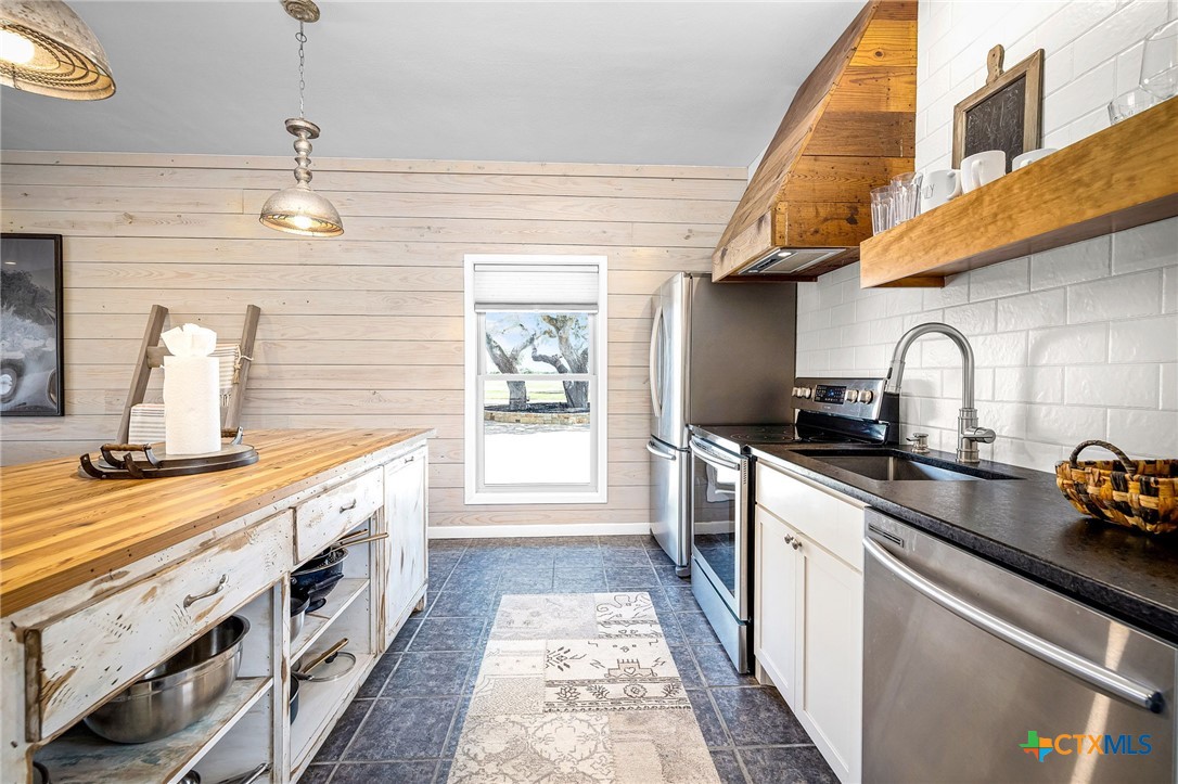 871 Chimney Valley Road Blanco, TX 78606 - Photo 36 of 45 a kitchen with stainless steel appliances a sink a stove oven and cabinets