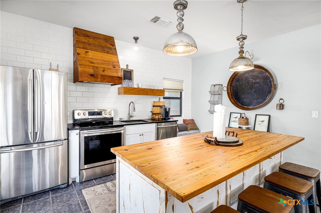 871 Chimney Valley Road Blanco, TX 78606 - Photo 37 of 45 a kitchen with stainless steel appliances granite countertop a sink a stove and refrigerator