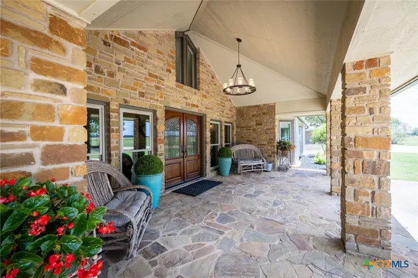 a view of a porch with dining table and chairs