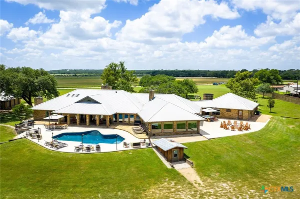 an aerial view of a house with swimming pool big yard and outdoor seating