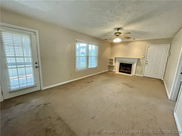 an empty room with closet and a ceiling fan