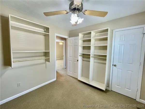 a view of an empty room with cabinet and a window