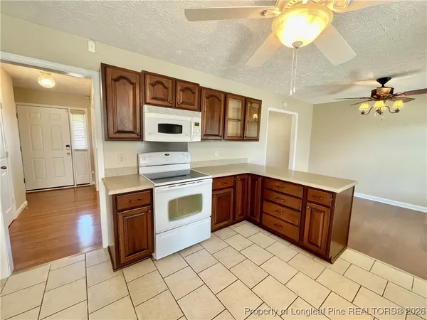 a kitchen with stainless steel appliances a stove a microwave and white cabinets