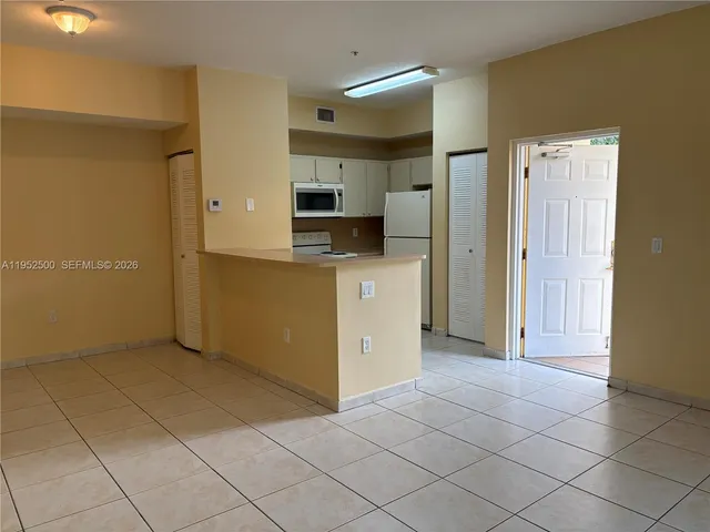 a view of a kitchen with a sink and a refrigerator
