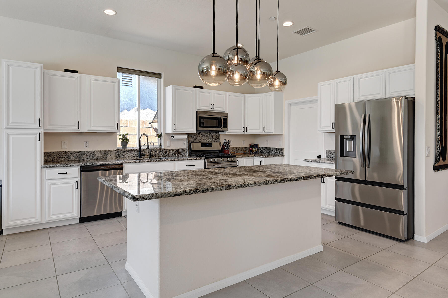 68965 Hermosillo Road Cathedral City, CA 92234 - Photo 4 of 40 a kitchen with stainless steel appliances granite countertop a sink a stove a refrigerator and cabinets
