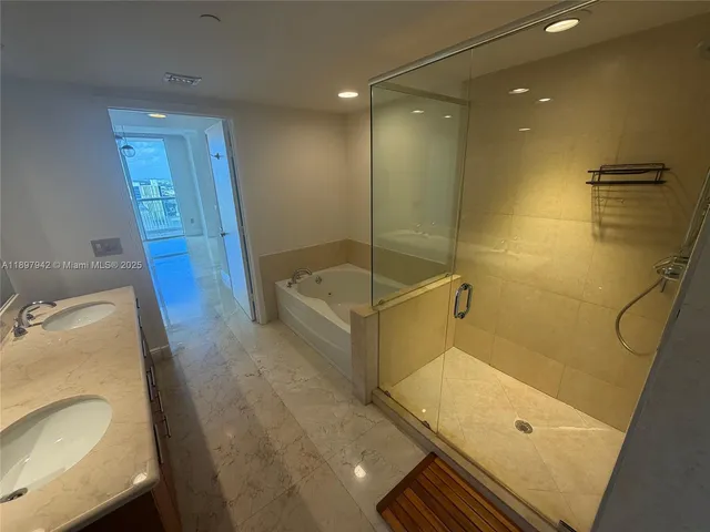 a bathroom with a tub sink and mirror