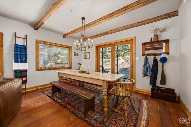 a view of a dining room with furniture a chandelier and wooden floor