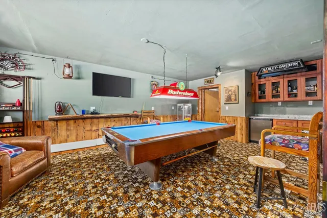 a living room with patio furniture and a flat screen tv