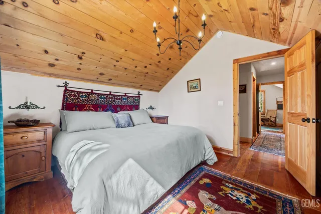 a spacious bedroom with a bed and wooden floor