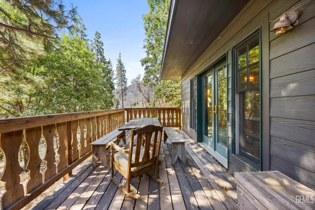 a balcony with wooden floor table and chairs
