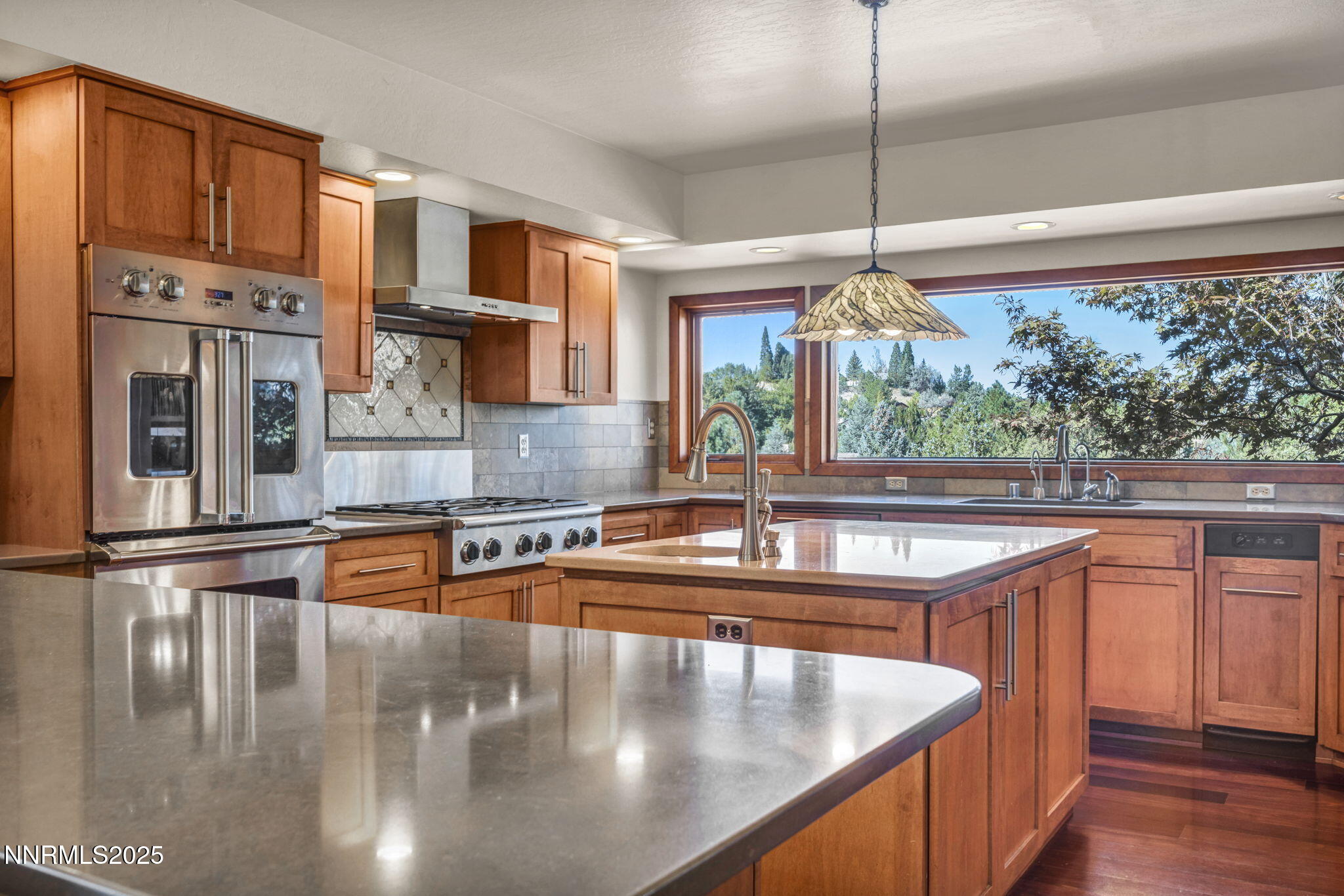 4283 Water Hole Road Reno, NV 89519 - Photo 12 of 62 a kitchen with stainless steel appliances granite countertop a sink a stove and a wooden floor