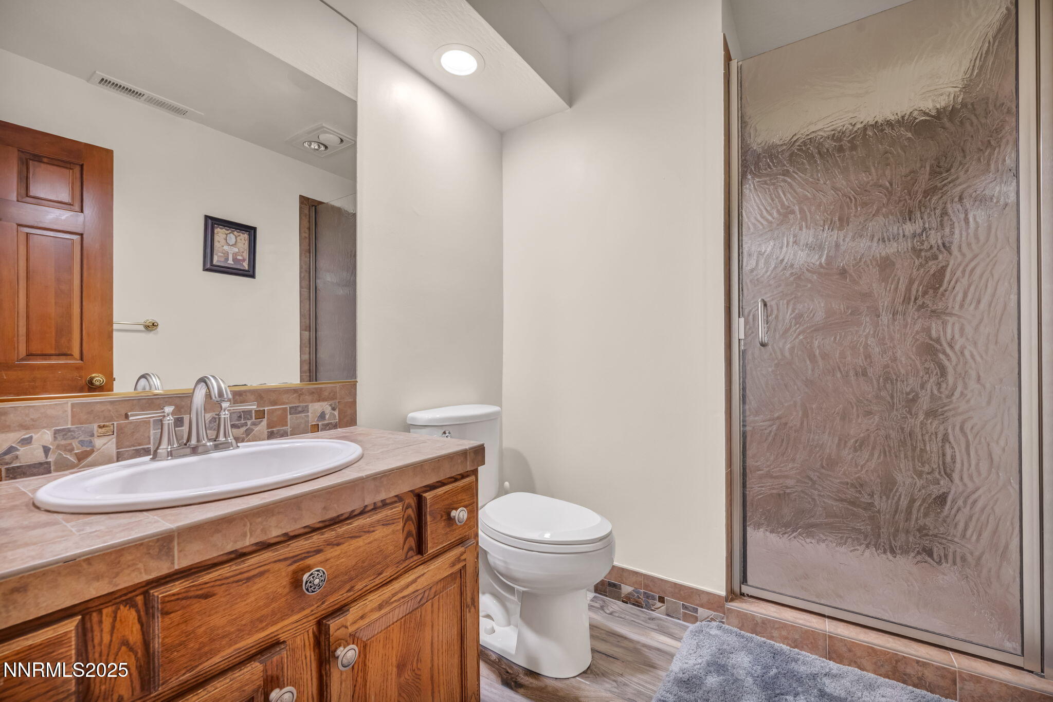 4283 Water Hole Road Reno, NV 89519 - Photo 44 of 62 a bathroom with a granite countertop sink a toilet and a mirror