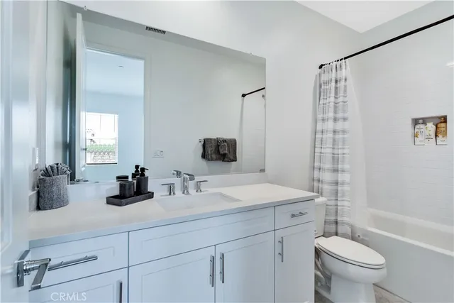 a bathroom with a double vanity sink toilet and shower