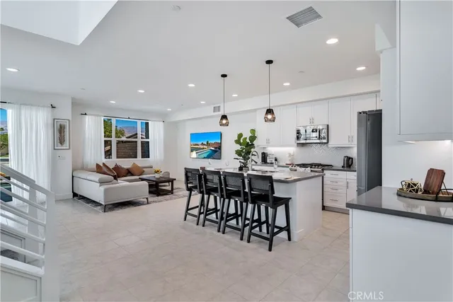 a kitchen with stainless steel appliances kitchen island granite countertop a sink and a refrigerator