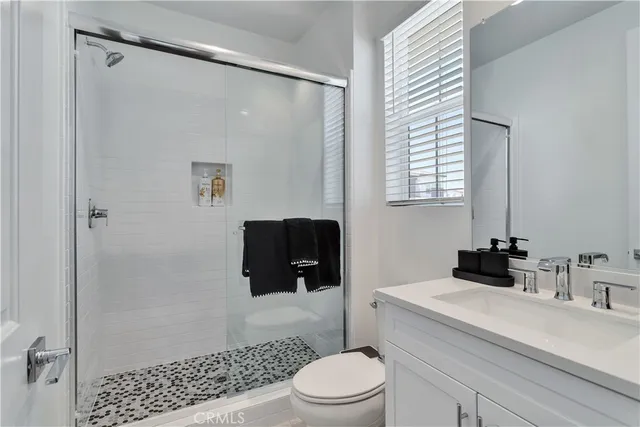 a bathroom with a sink a toilet a shower and a mirror