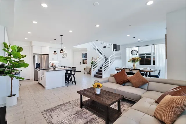 a living room with furniture kitchen view and a potted plant
