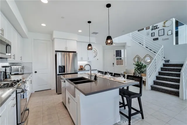 a kitchen that has a sink a microwave a stove and a refrigerator