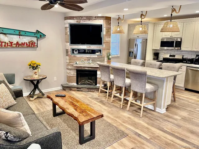 a living room with furniture a flat screen tv and a fireplace