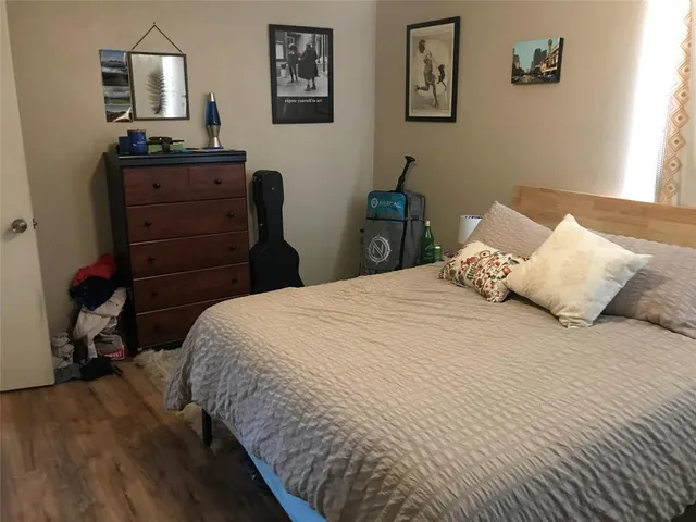 a bedroom with a bed a table and a potted plant