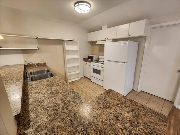 a kitchen with granite countertop a sink and cabinets