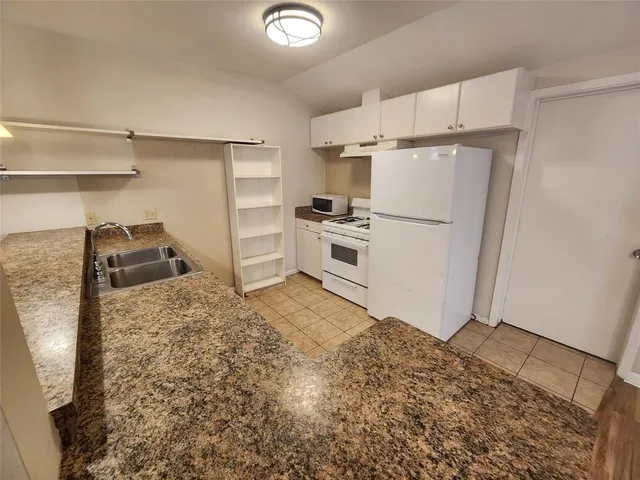a kitchen with granite countertop a sink and cabinets