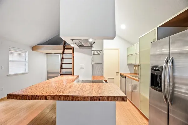 a kitchen with granite countertop a refrigerator and a stove top oven