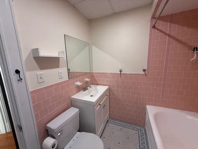a bathroom with a toilet sink and mirror