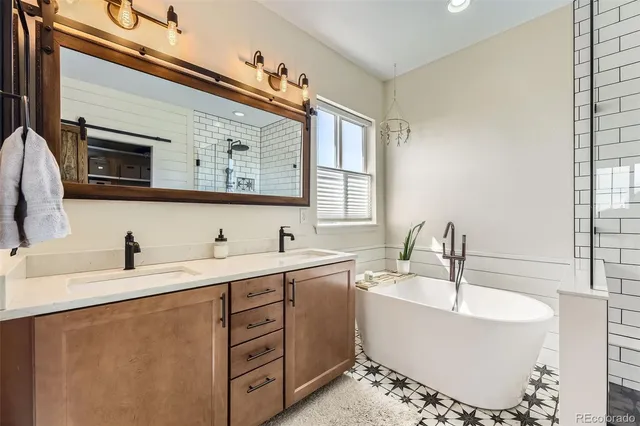 a bathroom with a double vanity sink a mirror and a bathtub
