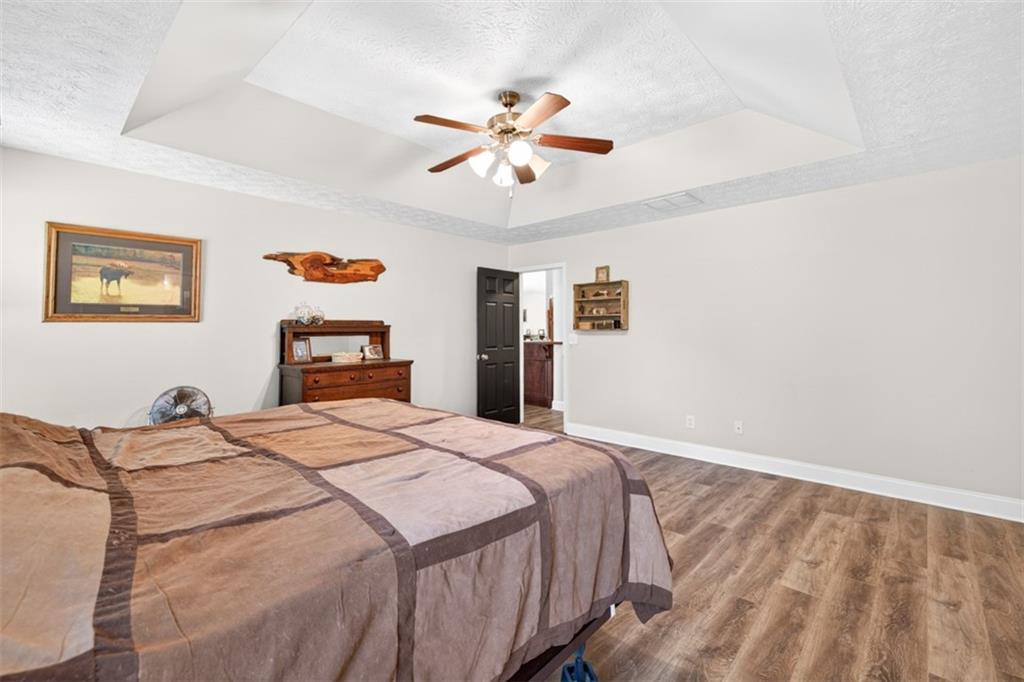 89 Katie Spring Lane Jefferson, GA 30549 - Photo 35 of 63 a bedroom with a large bed and a chandelier